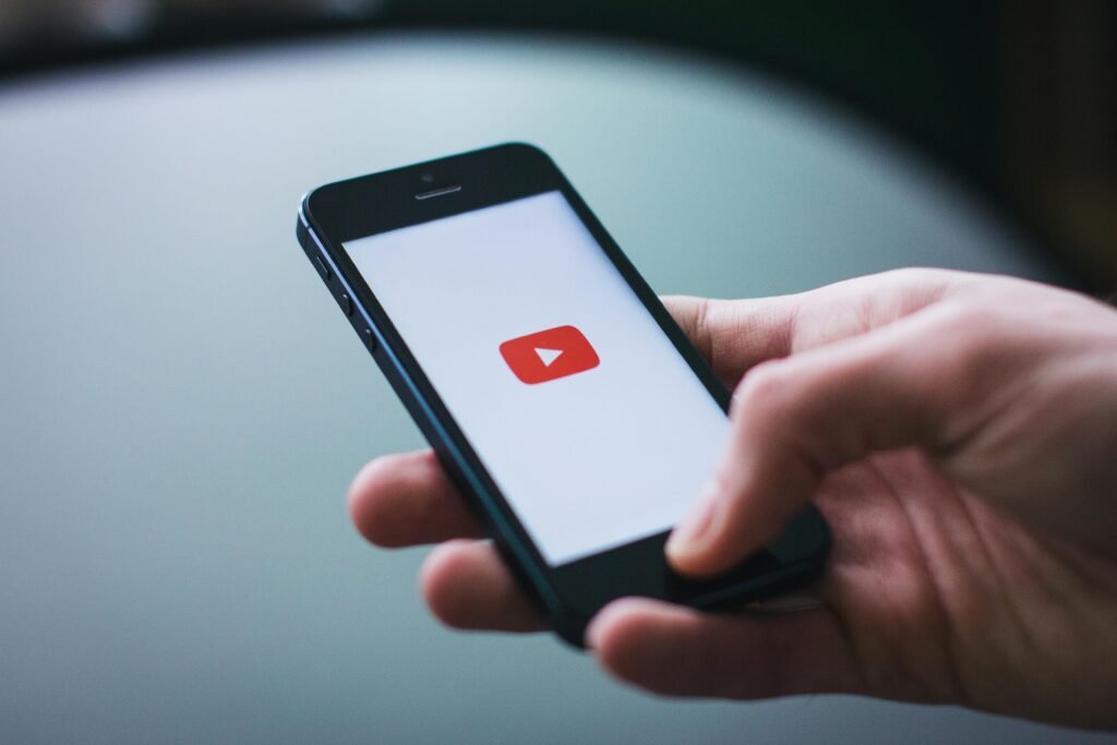 pexels-photo-34407 Close-up of a hand holding a smartphone displaying the YouTube app on the screen.